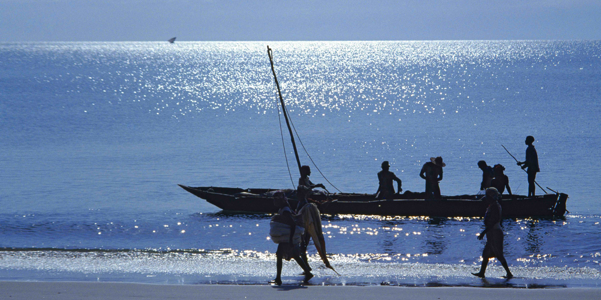 Strand mit einem Fischerboot und Personen